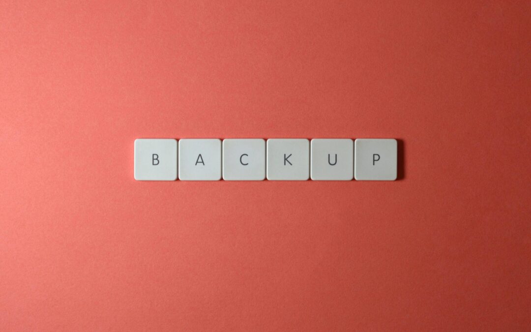 Free Close-up of keyboard keys spelling 'BACKUP' placed on a coral-colored surface. Stock Photo